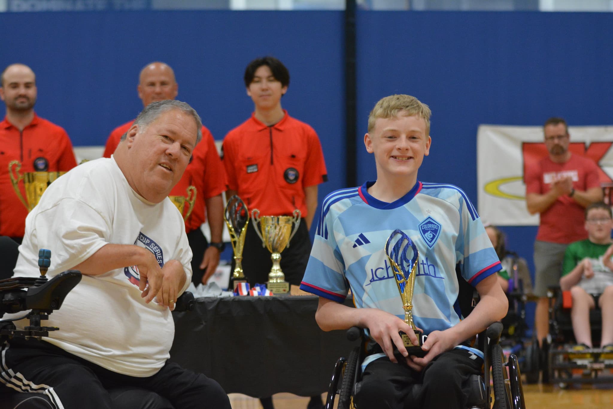 Rolling Rapids player holding a championship trophy